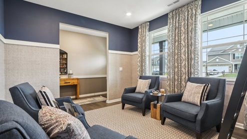 Office space with neutral carpet, windows, and simple decor.