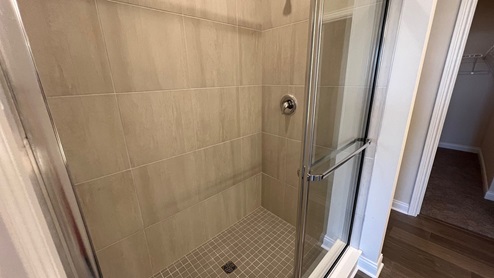 Primary bathroom with tiled shower.