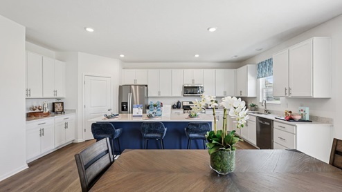 Interior kitchen with center island and white cabinets