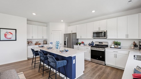 Interior kitchen with center island and white cabinets