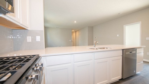 The gorgeous kitchen features stunning quartz countertops, breakfast bar and a pantry.