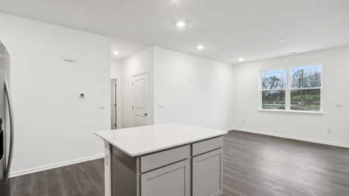 Kitchen with gray cabinets, quartz couontertops, and island.