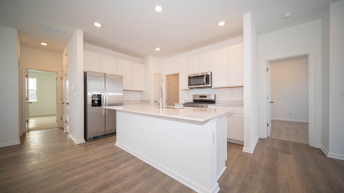 Kitchen with white cabinets, and island and stainless steel appliances.