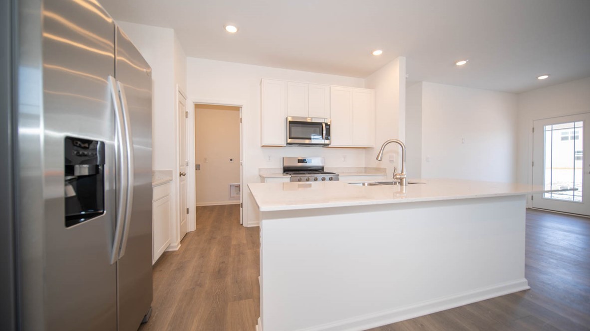 Kitchen island with quartz countertop, a double sink and nickel fixture.
