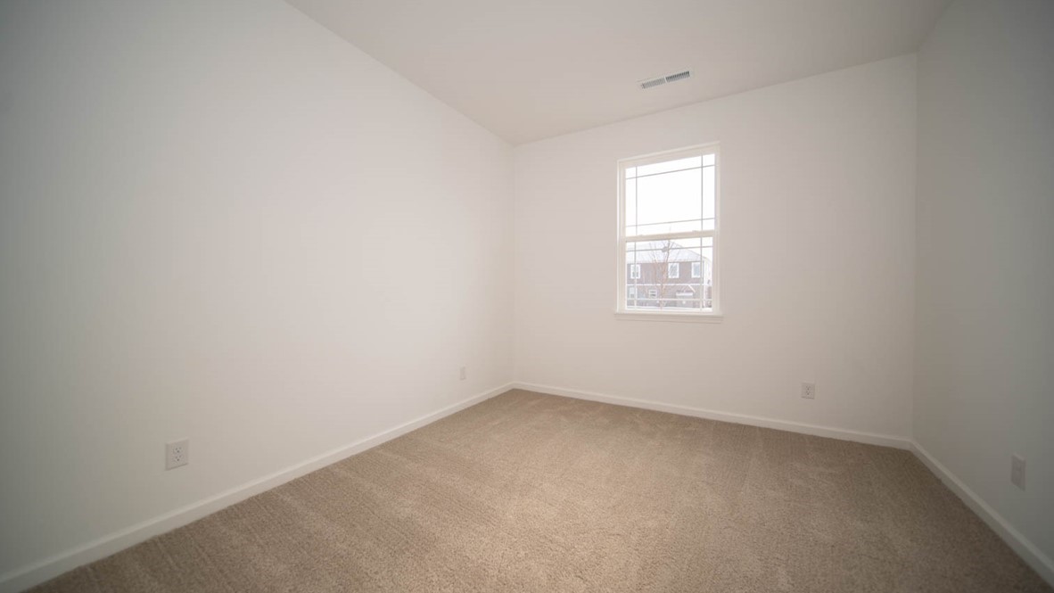 Bedroom two with a single window and carpet flooring.