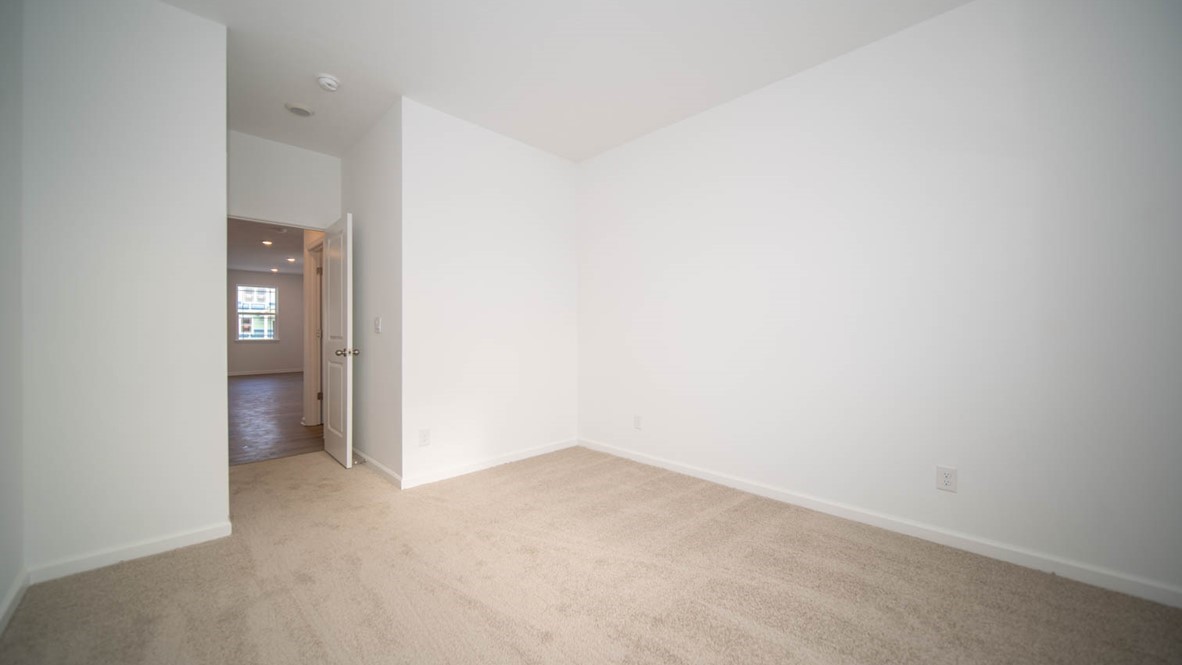 Bedroom two with a single window and carpet flooring.