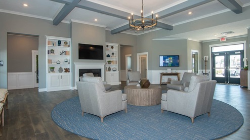 Lounging area located inside the amentiy center with a tv and fireplace.