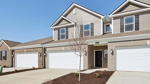 Exterior two-story townhomes with a two-car garage, brick covering the first floor, and off-white siding on the second floor.