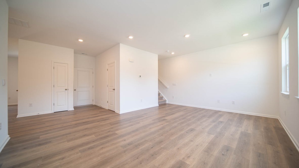 Great room interior with laminate flooring and stair access to second floor.