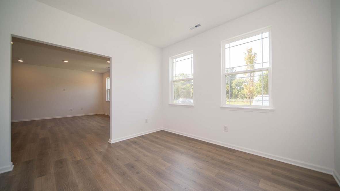 Front room flex room with tow windows and lamiante flooring adjacent to the great room.