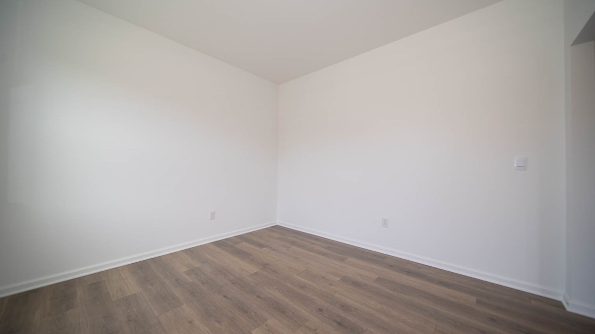 Front room flex room with tow windows and laminate flooring adjacent to the great room.