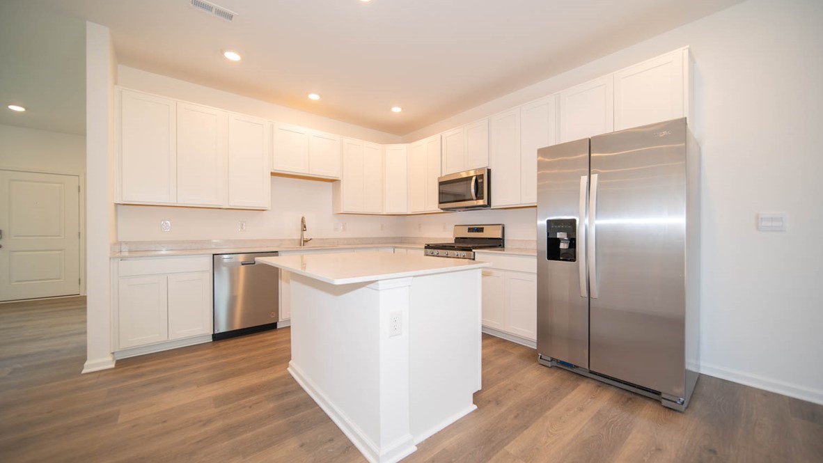 Kitchen with white cabinets, stainless steel appliances and an island.