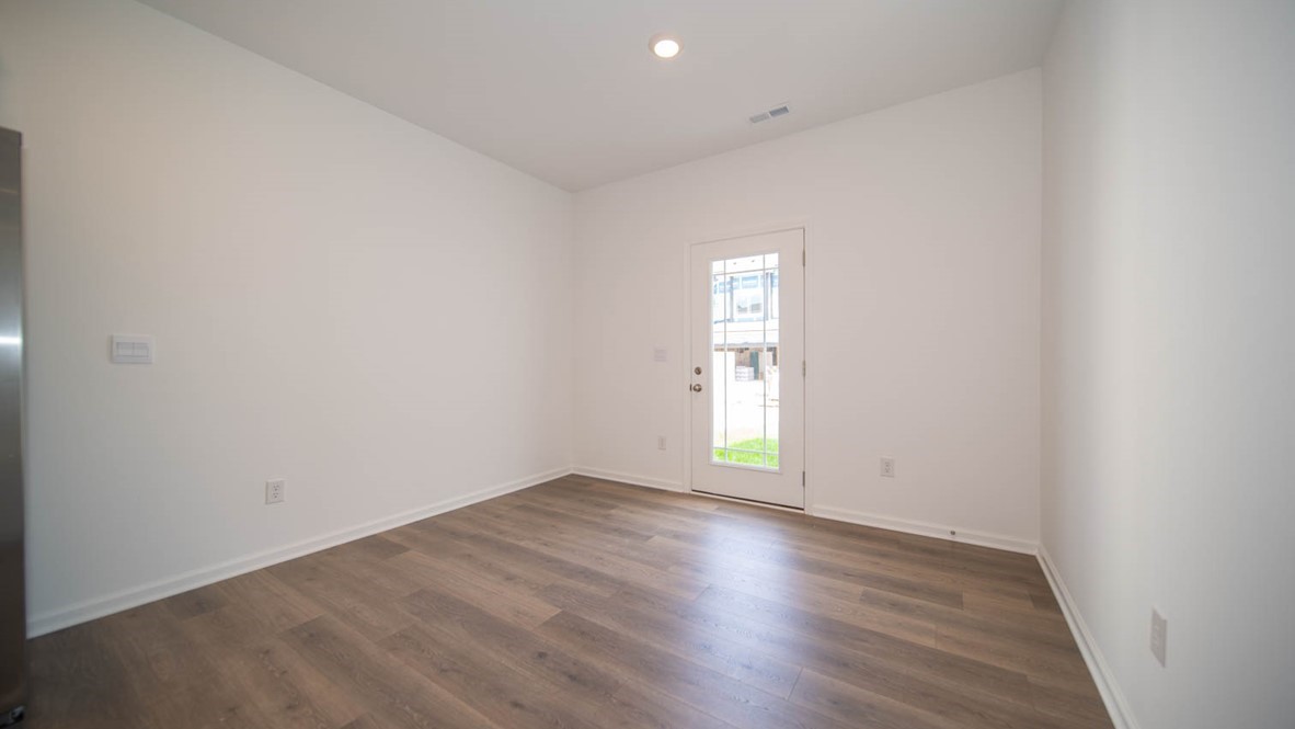 Dining nook with vinyl flooring and exterior door.