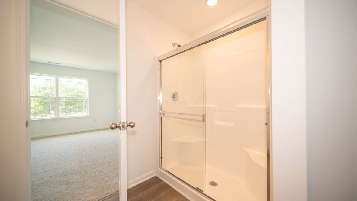Stand-up shower with sliding glass door in the primary bathroom.
