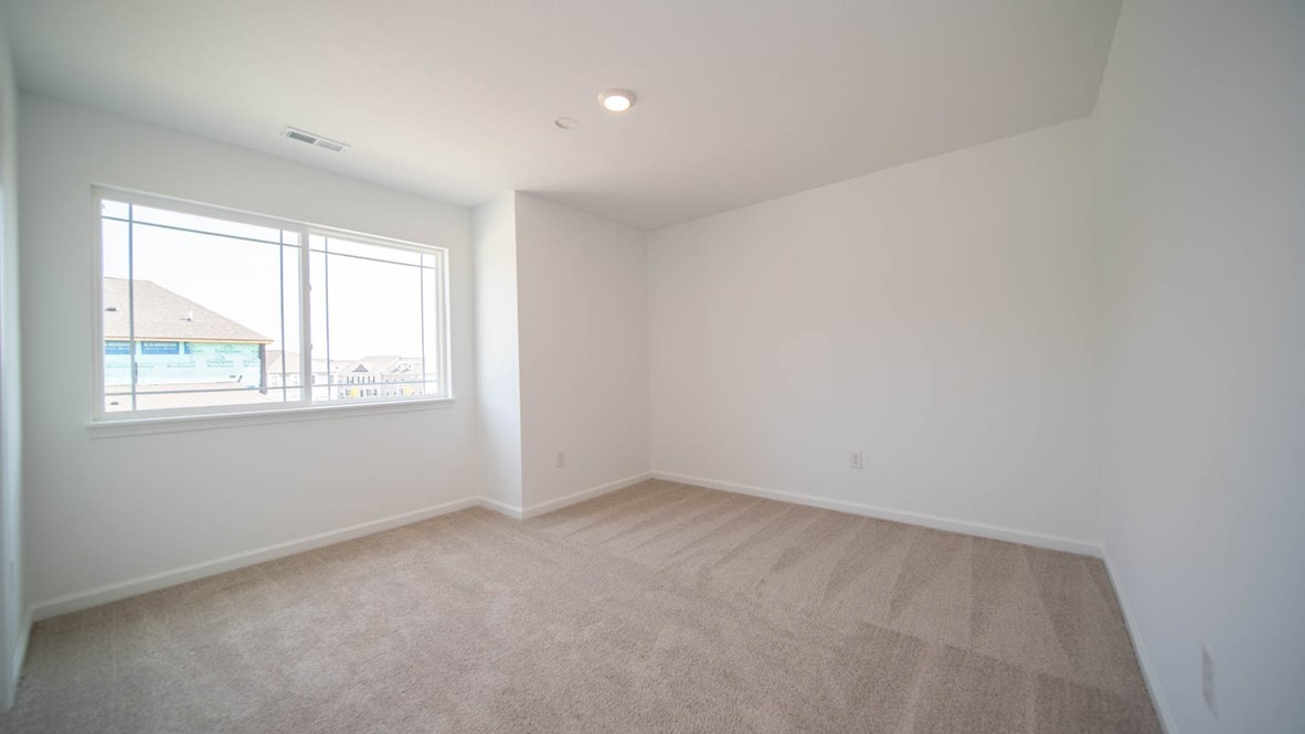 Third bedroom with a double window and carpet flooring.