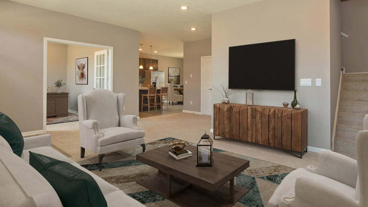 Great room interior with carpet flooring and stair access to second floor and adjacent to flex room.