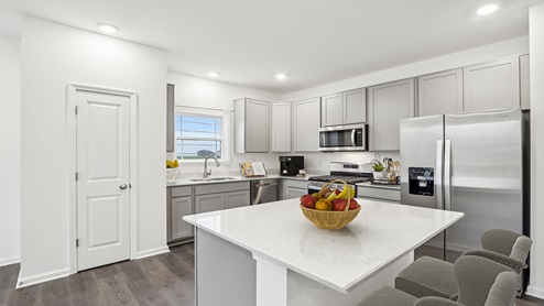 Drescher kitchen with white cabinets, wood laminate flooring, and stainless steel appliances.