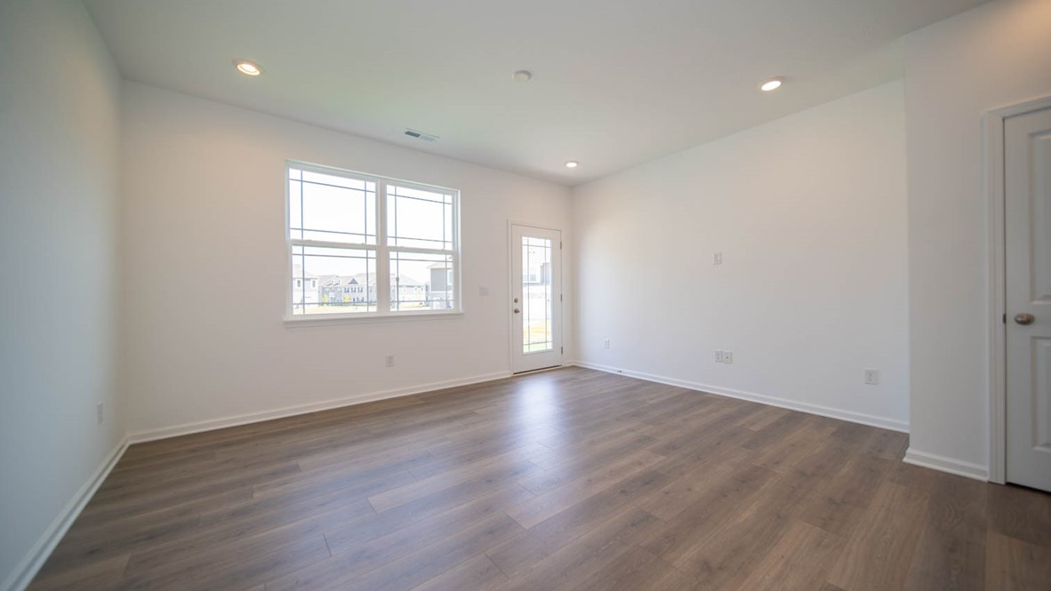 Great room with a double-window, vinyl flooring, and an exterior door.