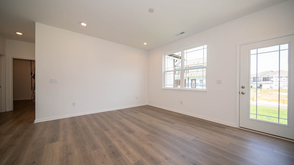 Great room with a double-window, vinyl flooring, and an exterior door.