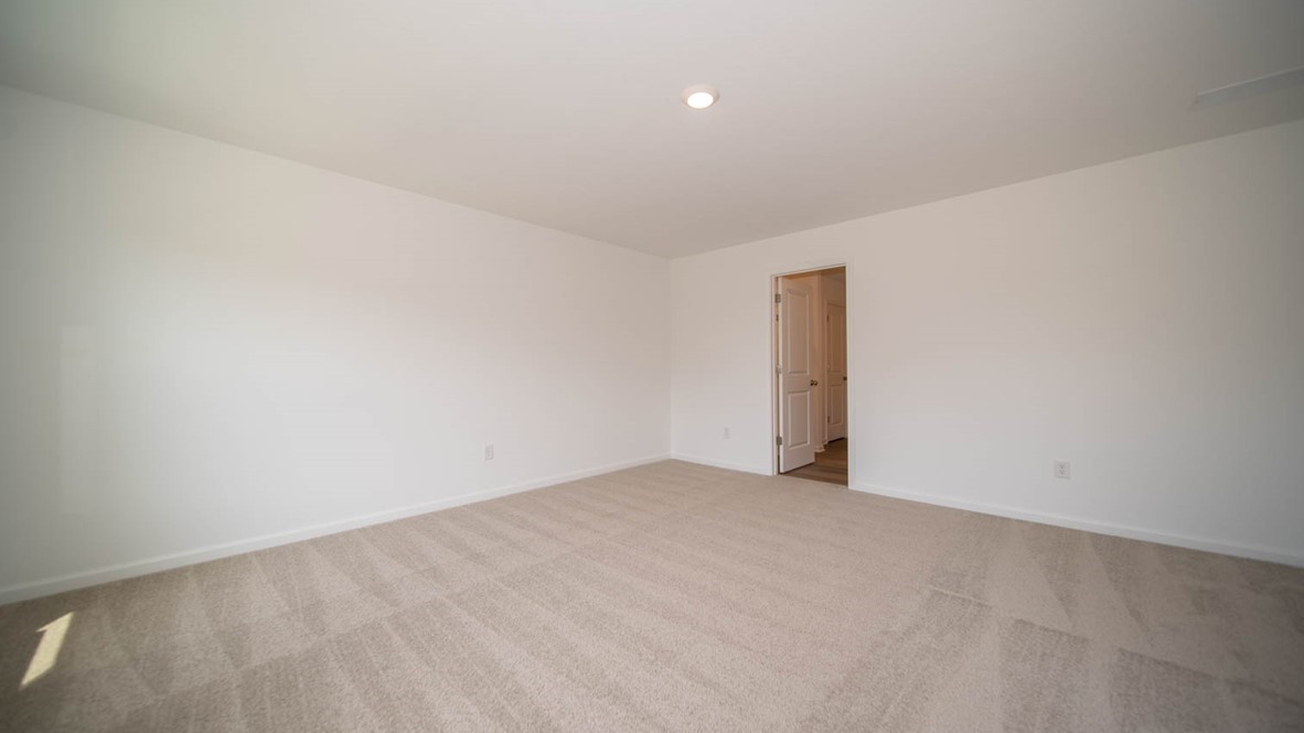 Primary bedroom with carpet flooring.