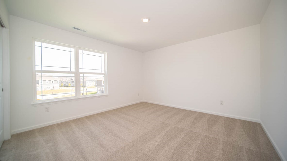Third bedroom with two windows and carpet flooring.