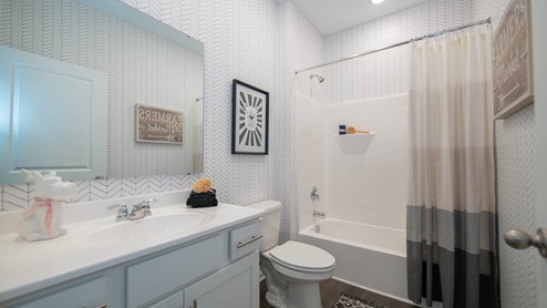 hall bathroom with white countertops and vanity