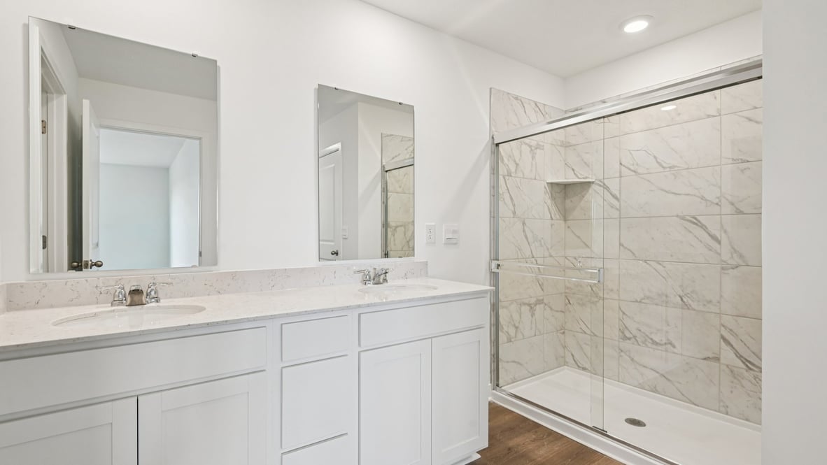 primary bathroom with dual vanity and walk-in shower