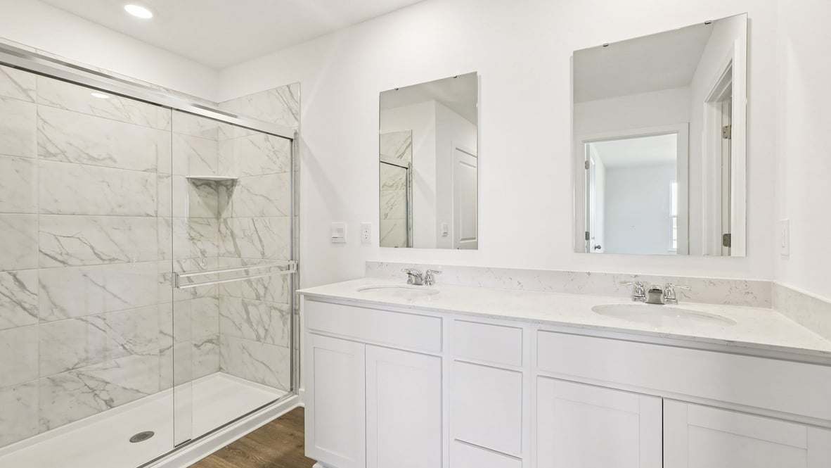 primary bathroom with dual vanity and walk-in shower