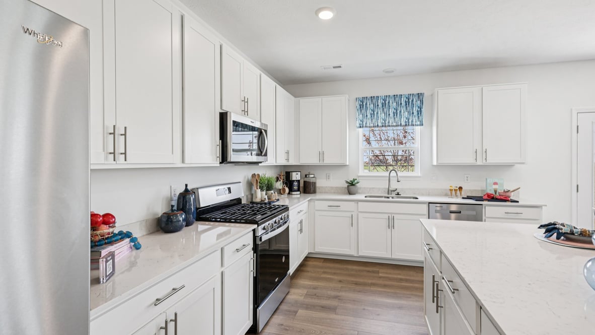 Interior kitchen with center island and white cabinets
