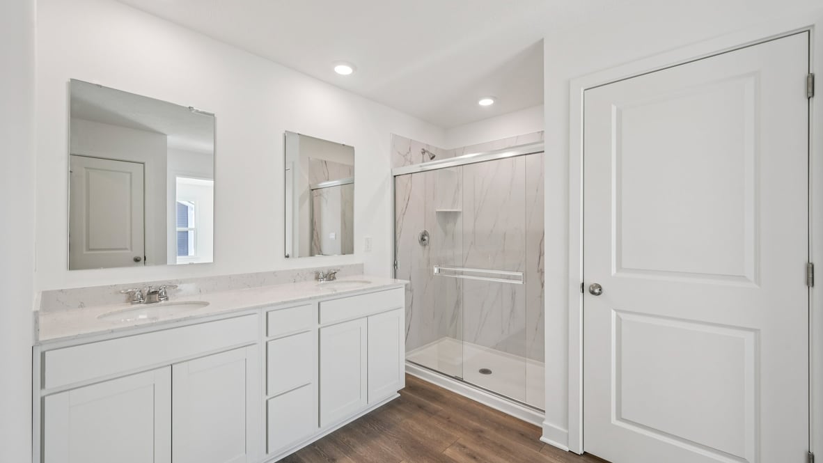 primary bathroom with dual vanity and walk-in shower
