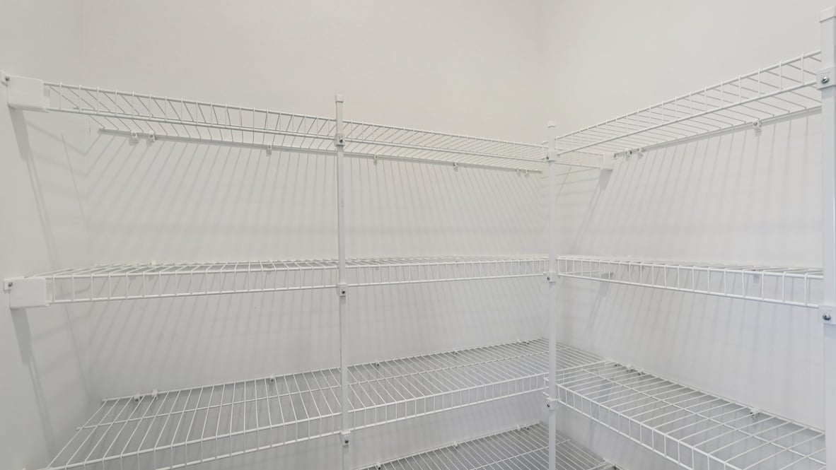 Interior view of the kitchen pantry with shelving for organized storage