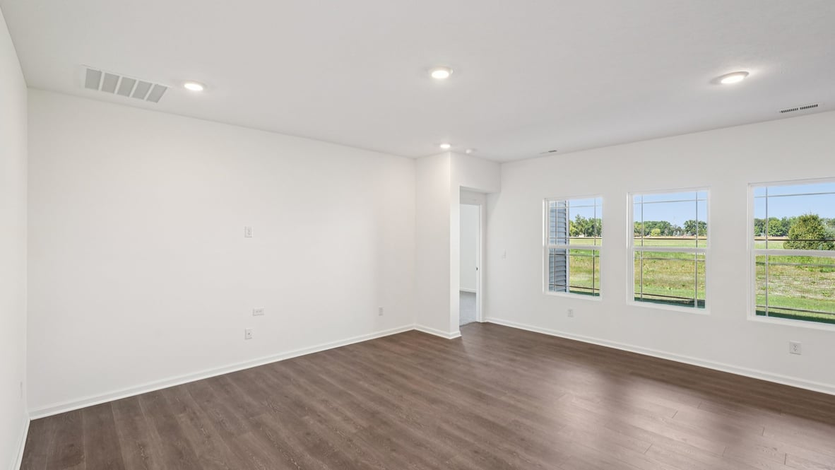 Living room view toward outside windows and primary bedroom access