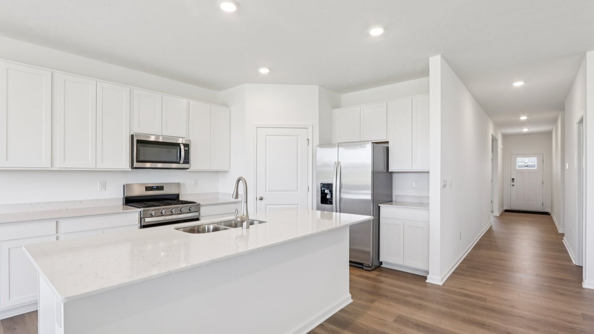 kitchen with white cabinets, island, pantry and stainless steel appliances