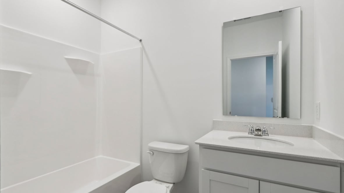hall bathroom with gray cabinets sink commode and tub shower