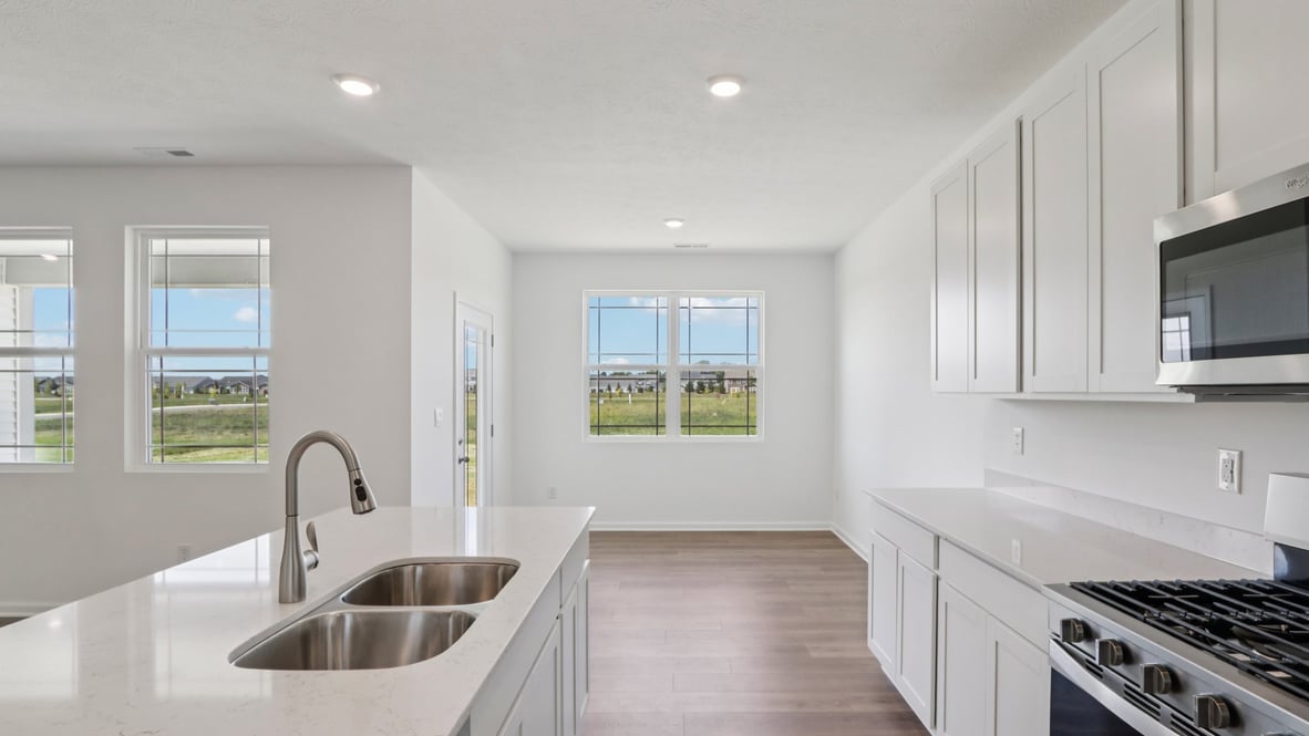 kitchen with white cabinets, island, pantry and stainless steel appliances