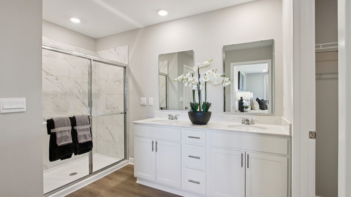 primary bathroom with dual vanity and walk-in shower