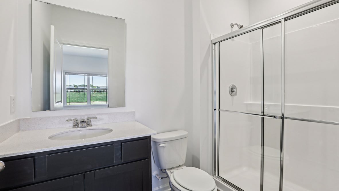 hall bathroom with vanity commode and shower