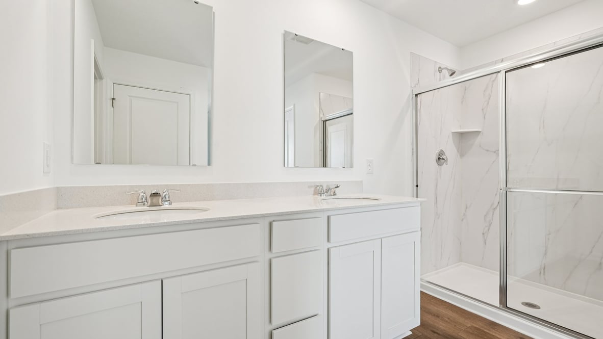 primary bathroom with dual vanity and walk-in shower