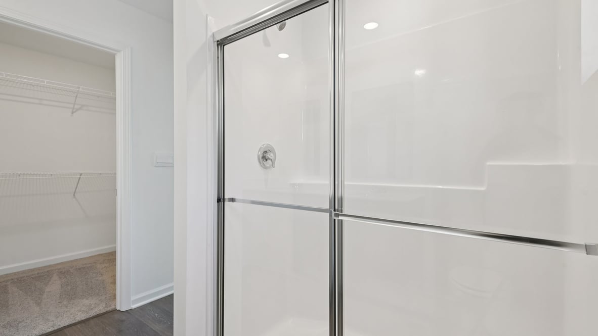 primary bathroom with walk in shower and large walk in closet