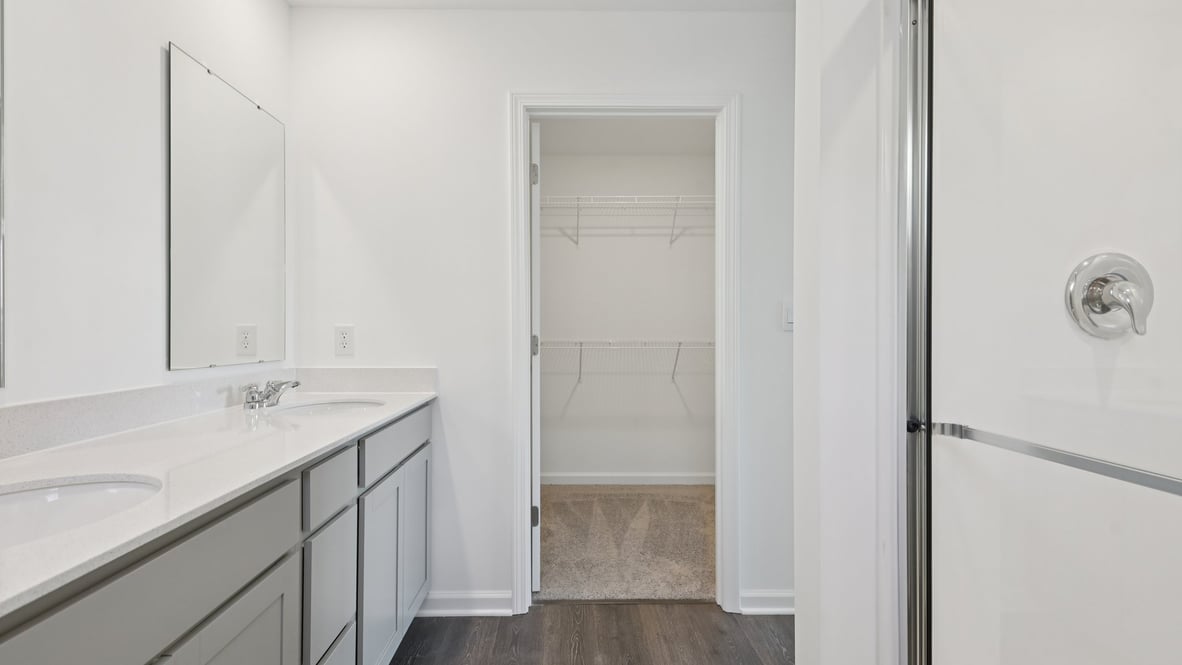 primary bathroom with walk in shower and large walk in closet