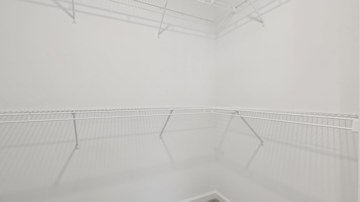 primary bathroom with walk in shower and large walk in closet