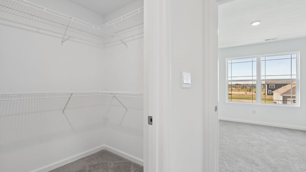 primary bathroom with walk in shower and large walk in closet