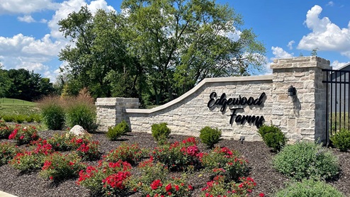 welcome to edgewood farms - entry monument with red flowers