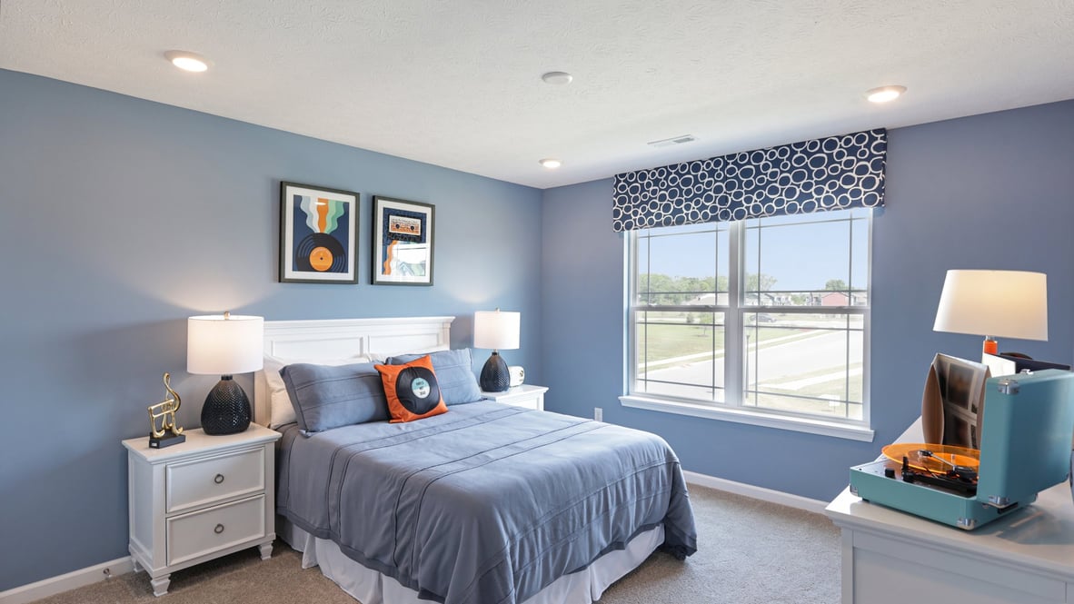bedroom with beige carpet, blue walls and a window