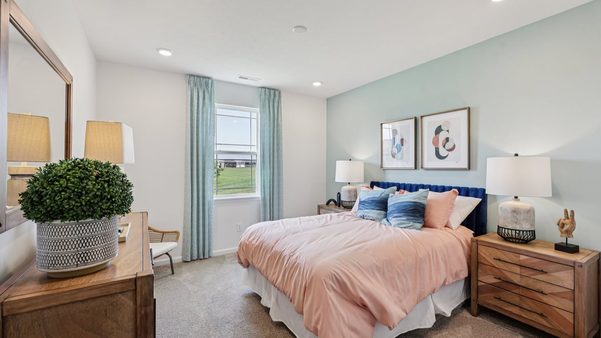 bedroom with beige carpet, a blue accent wall and a window