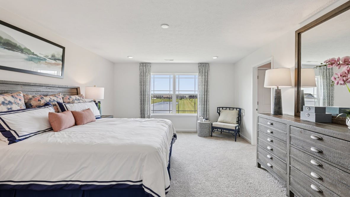 bedroom with beige carpet, beige walls and a window