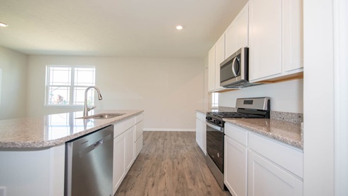 The kitchen has quartz countertops and stainless appliances