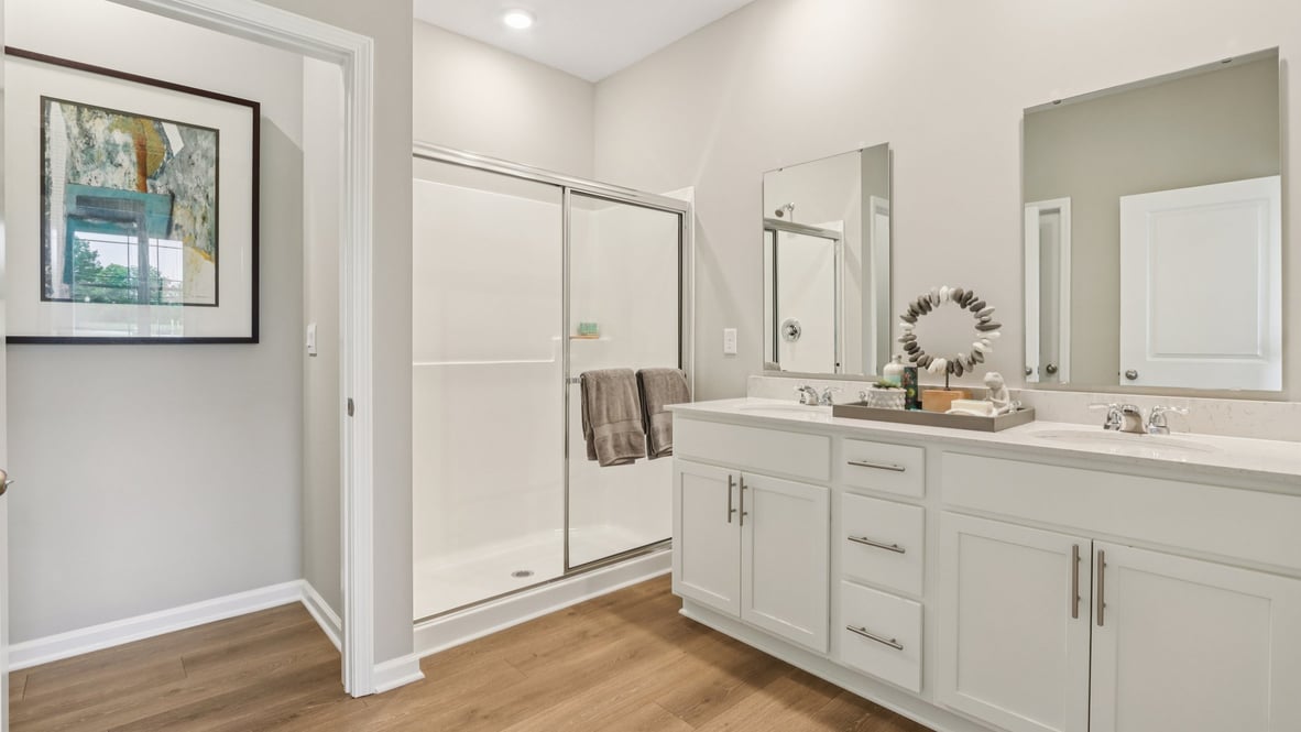 primary bathroom with dual vanity and walk-in closet