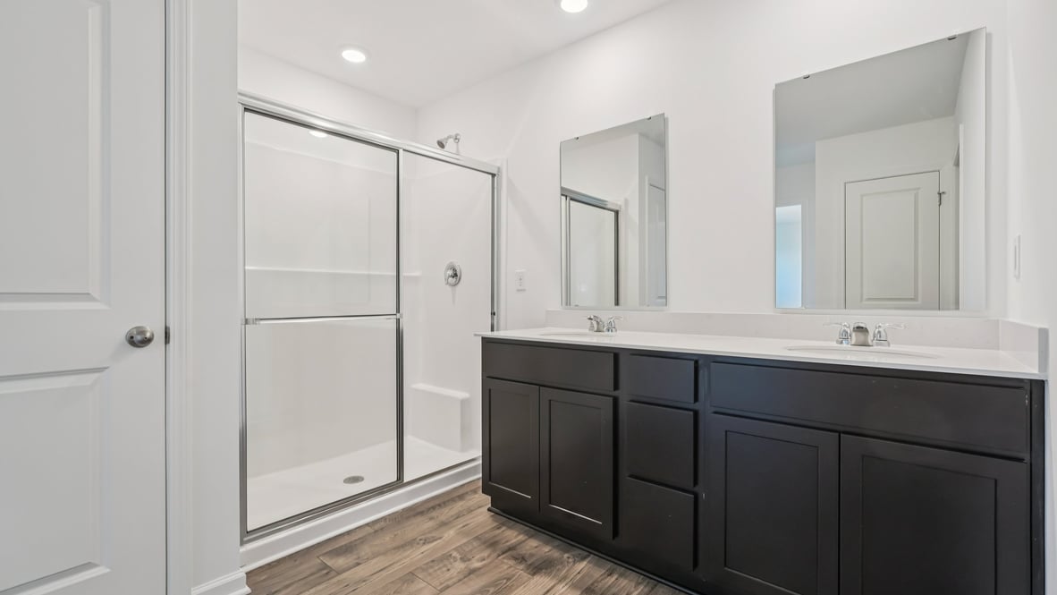 primary bathroom with dual vanity and walk-in shower