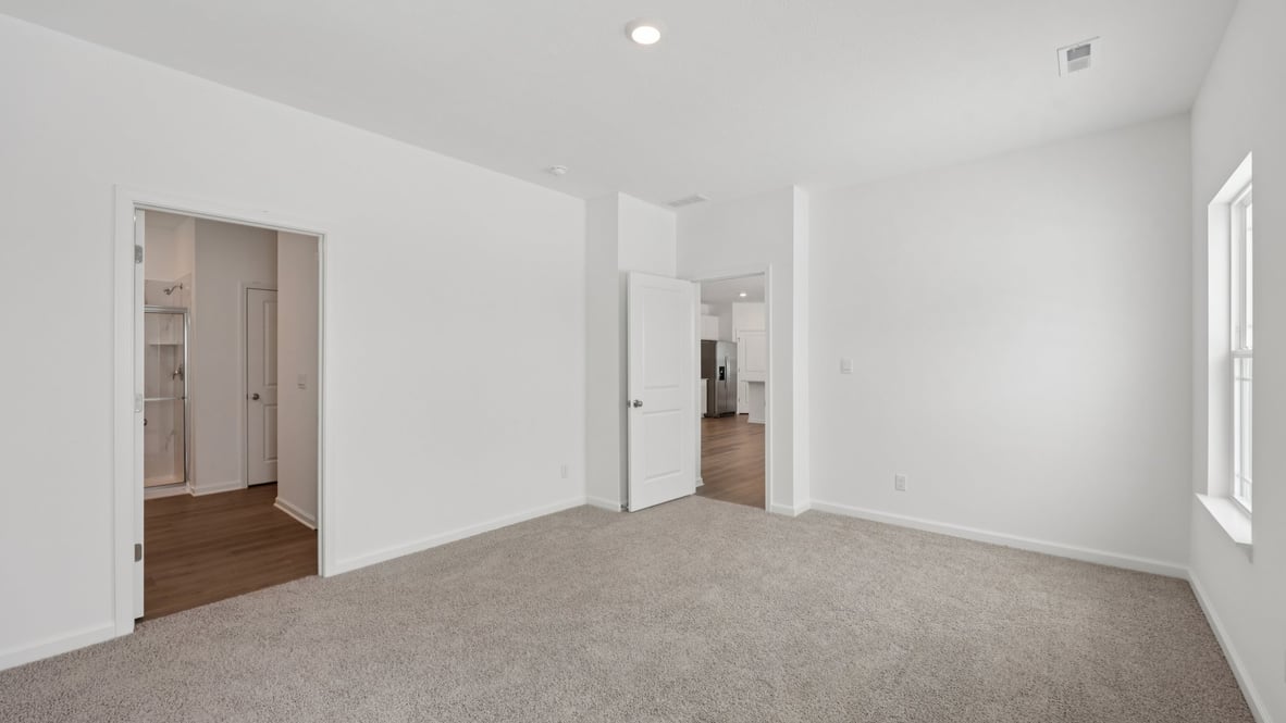 Primary bedroom features ample space, double windows, soft carpet, a stylish walk-in closet with a private ensuite